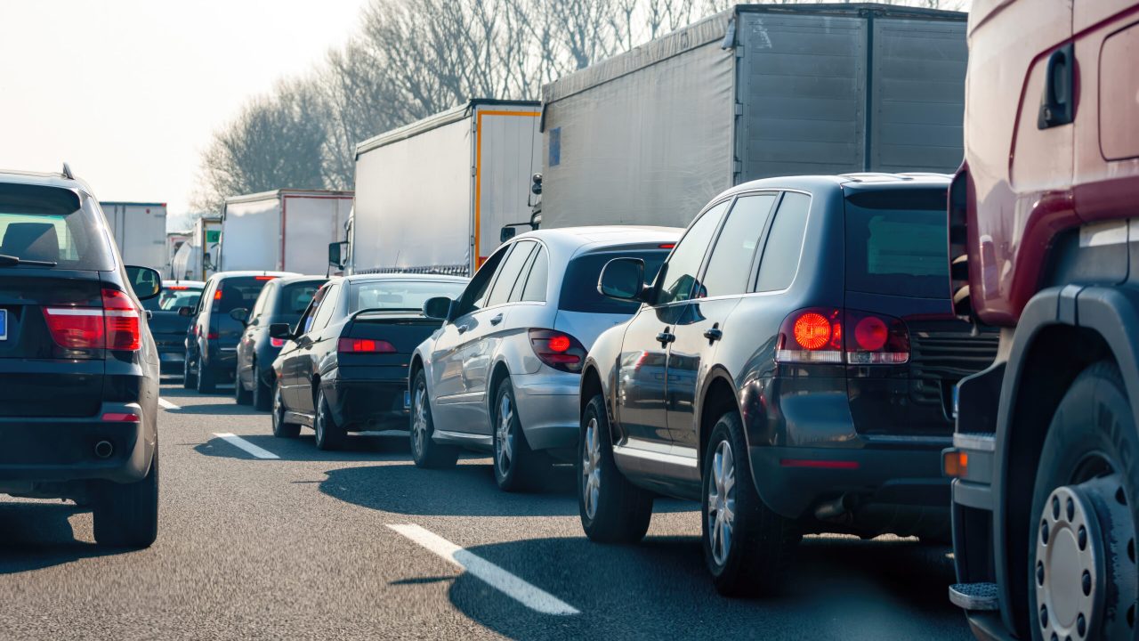 Cars and trucks are stuck in a traffic jam on a highway, creating congestion and delays for commuters