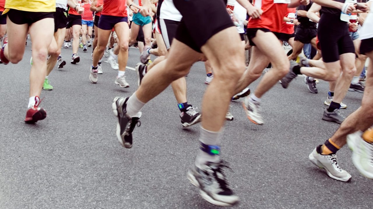 Marathon runners in city run, motion blur